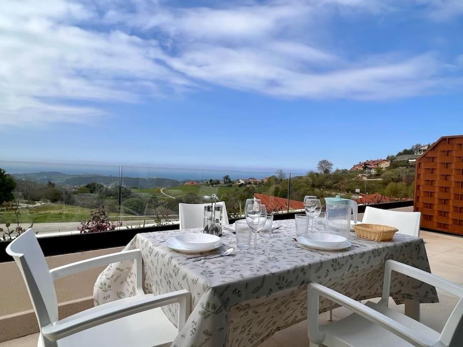 un balcón con una mesa blanca con gafas y sillas. en Apartamento Puerta de Comillas - Monabri, en Canales