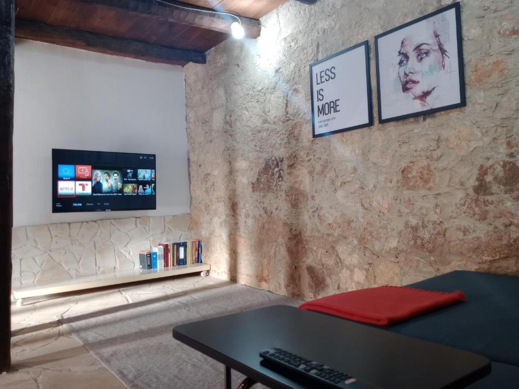 sala de estar con mesa y TV en Galileo Cottage House (BREAKBOOKING CY), en Parekklisha