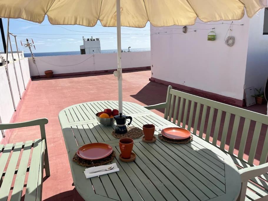 una mesa con platos de comida y una sombrilla en Casa Evan El charco, en Arrecife