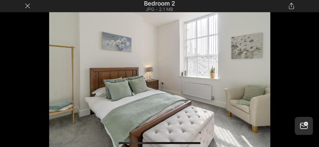 een slaapkamer met een bed, een stoel en een raam bij 97a 97b Captains House in Plymouth