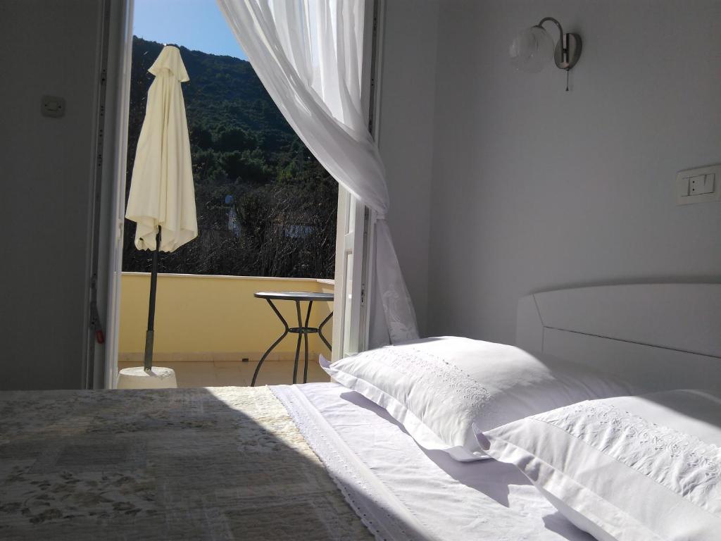 a white bedroom with a bed and a window at Lemon house in Vis