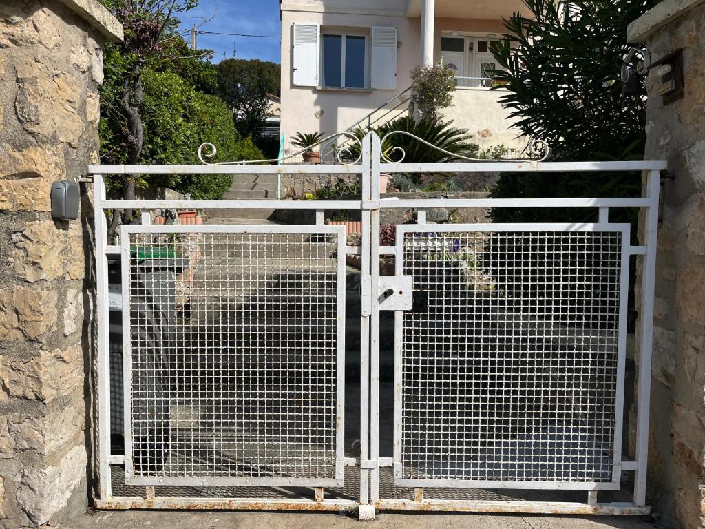 a white gate in front of a house at Belle vue sur mer, très près du port de Sanary in Sanary-sur-Mer