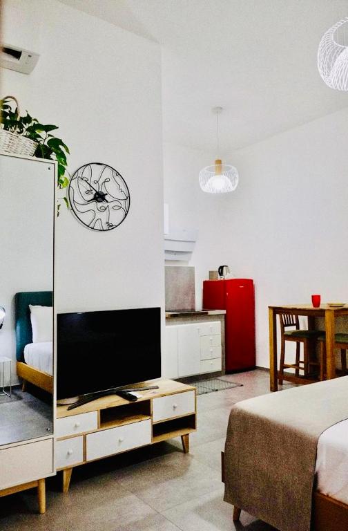 a living room with a tv and a clock on the wall at Casa Artesano Trapani in Trapani