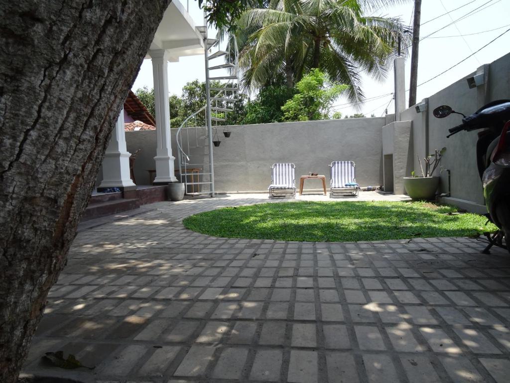 two chairs sitting in a yard with a house at Ok Cabana Negombo in Negombo