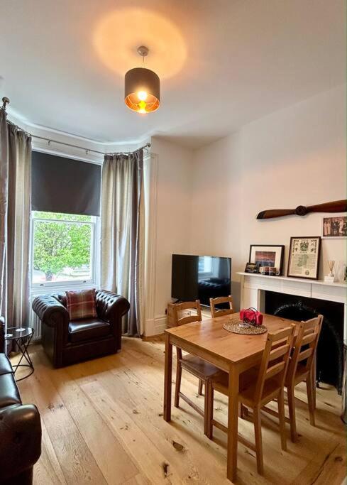 a living room with a table and a couch at 1 bedroom apartment in Shepherds Bush, London in London