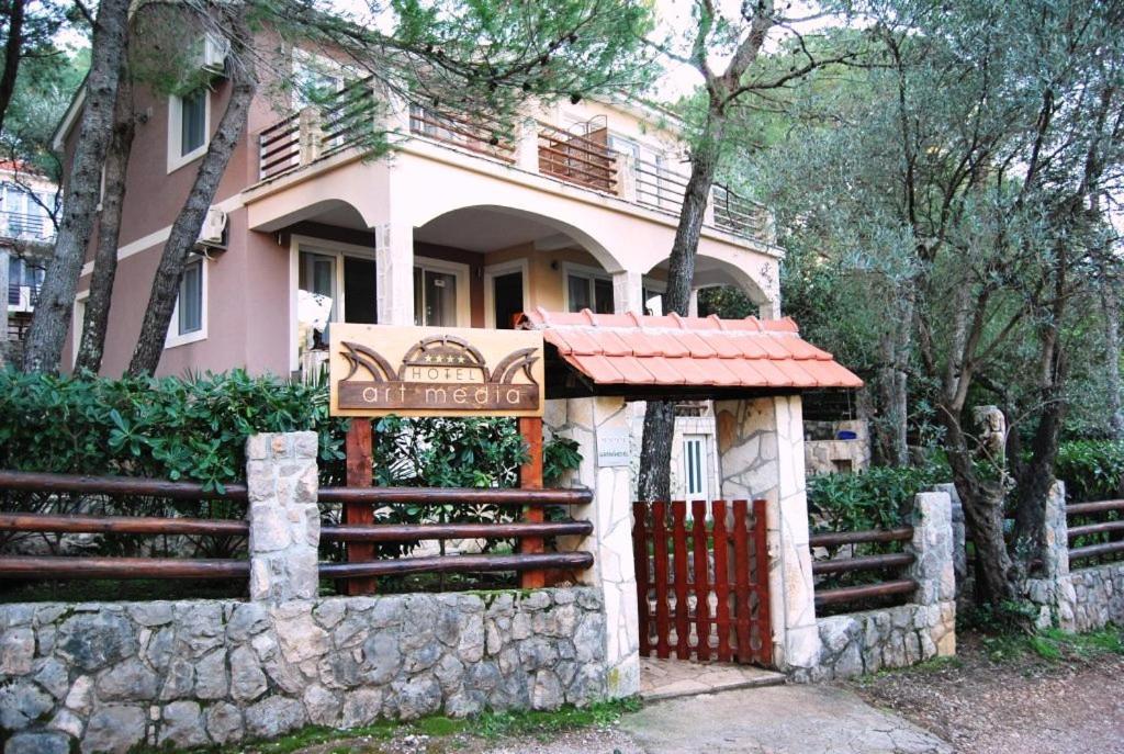 a large house with a fence in front of it at Hotel Art Media in Herceg-Novi