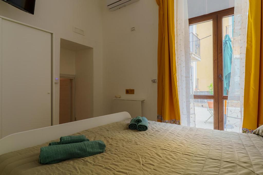 a bedroom with a bed with two towels on it at Casta Diva Holiday Rooms in Catania