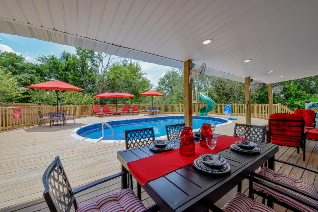 a patio with a table and chairs and a pool at Bama Cottage in Tuscaloosa