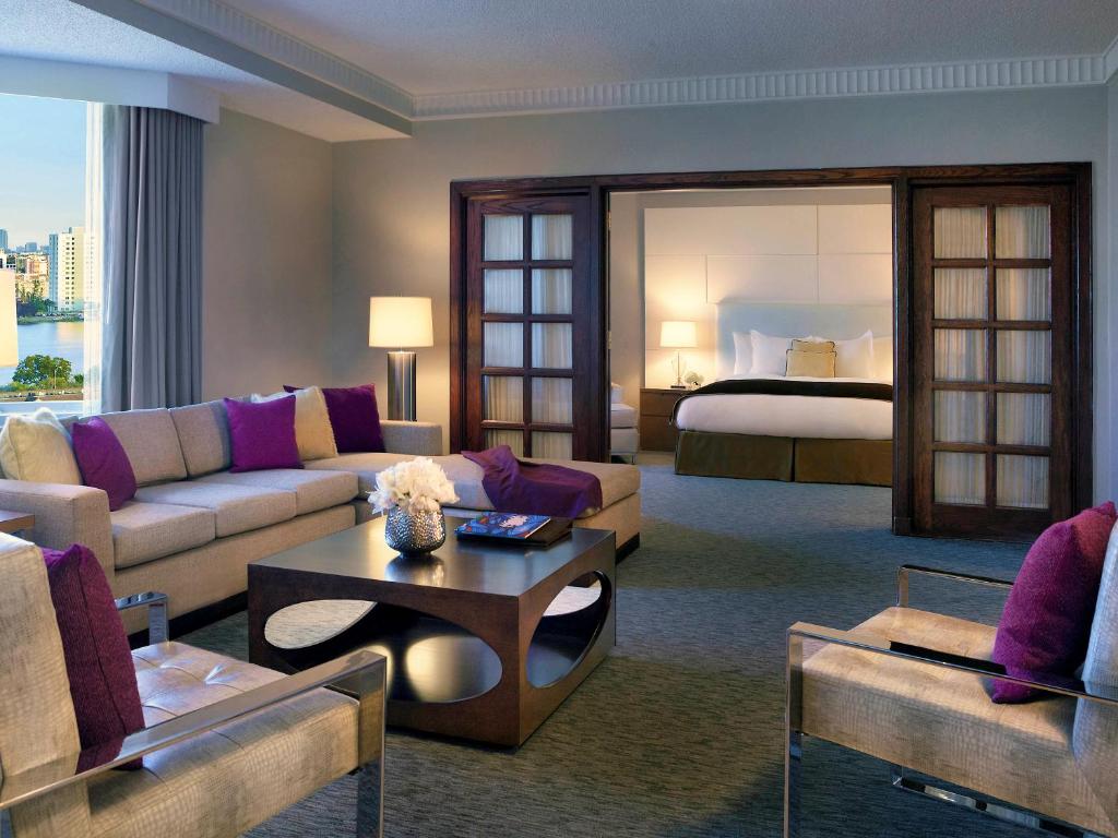 a living room with a couch and a bed at Pullman Miami Airport in Miami