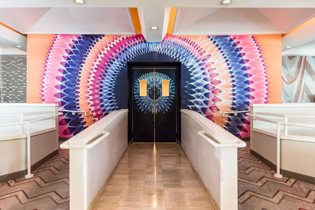 a hallway with a colorful wall with a door at Pullman Miami Airport in Miami