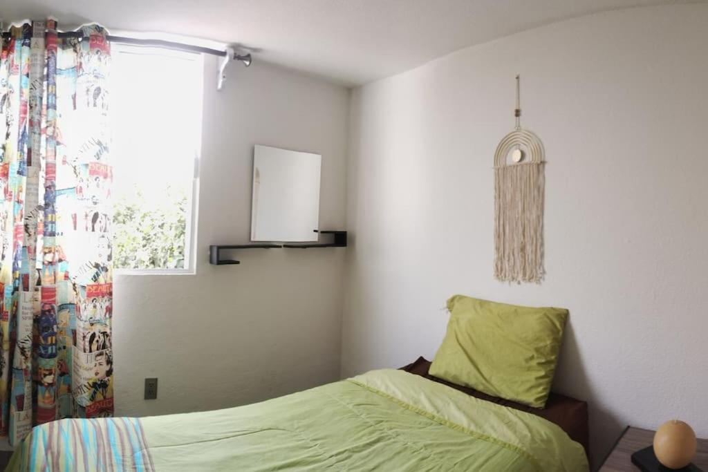 - une chambre avec un lit vert et une fenêtre dans l'établissement Casa 2 recámaras, à Mexico