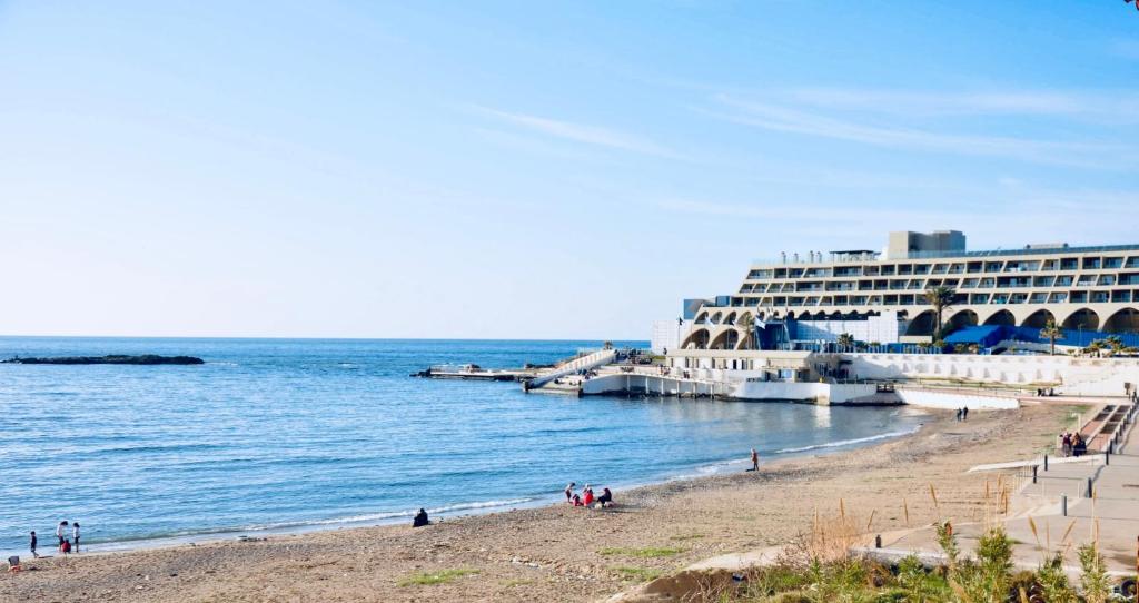 una playa con un gran hotel y un edificio en Confortables location familiale vue sur mer à Sidj Fredj, en Staoueli