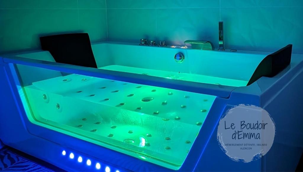 a bathroom with a green tub with a sink at Le Boudoir d'Emma - Jacuzzi privatif - Détente - Massage in Alençon