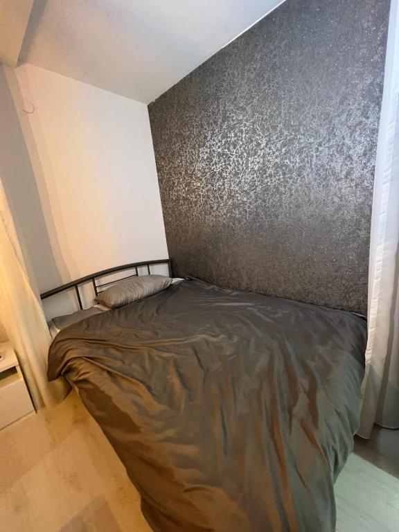 un piccolo letto in una stanza con parete di Apartman Paola - massage chair- 0-24 self check IN OUT- Županja a Županja