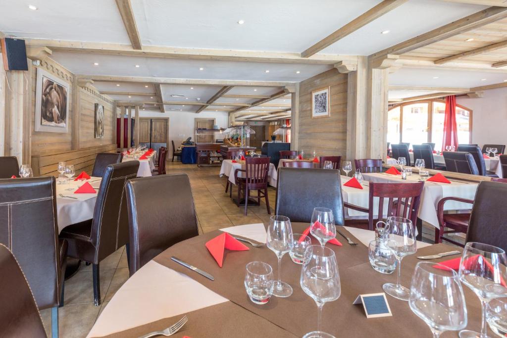 a restaurant with tables and chairs with wine glasses at Le Vancouver in La Plagne