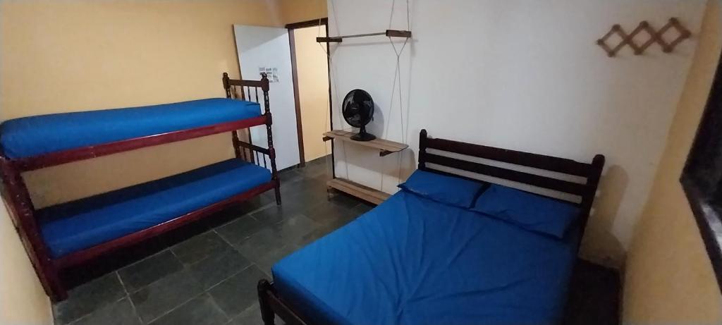 a room with two beds and a refrigerator at Centro Ilha comprida in Ilha Comprida