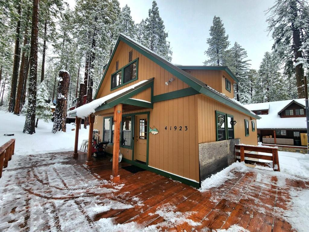 a house in the woods with snow on the ground at Toste Cabin- Spacious 3br Cabin In East Village! in Shaver Lake