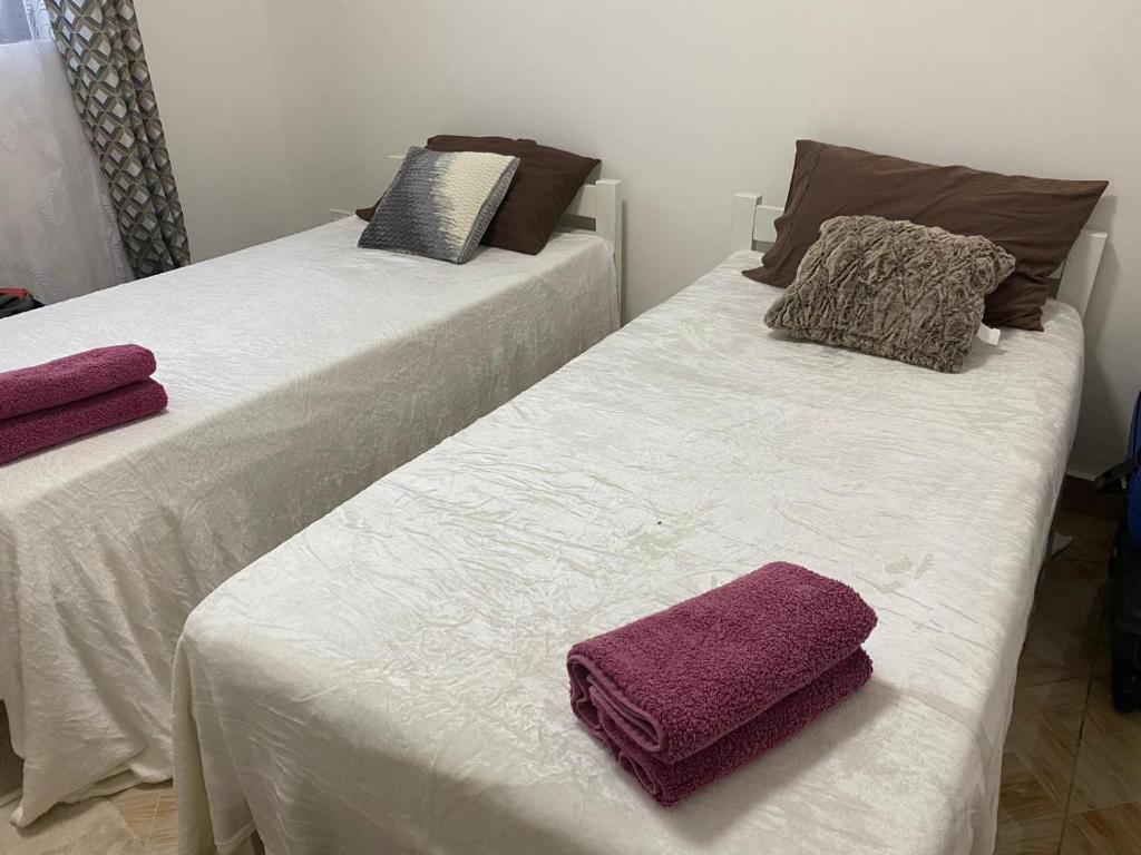 two beds with towels on them in a room at Peaceful Hills Self Catering Holiday House in Lusaka