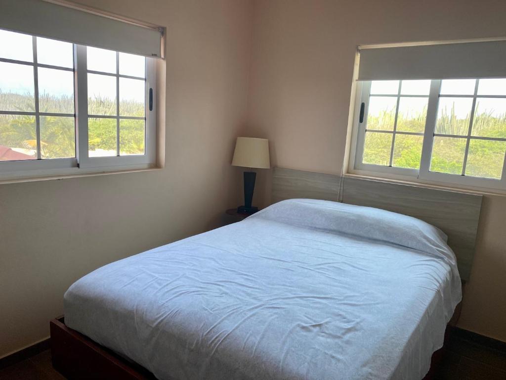 ein Schlafzimmer mit einem Bett und zwei Fenstern in der Unterkunft Cozy Apartment a 2 minutes to the Marriott in Noord