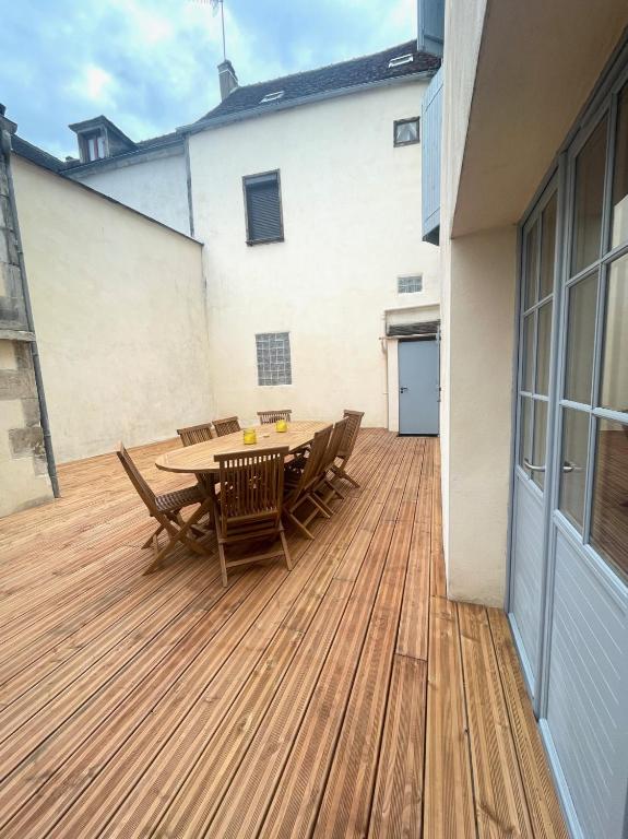 a wooden deck with a table and chairs on a building at Charmant logement rénové dans l’hyper centre in Auxerre