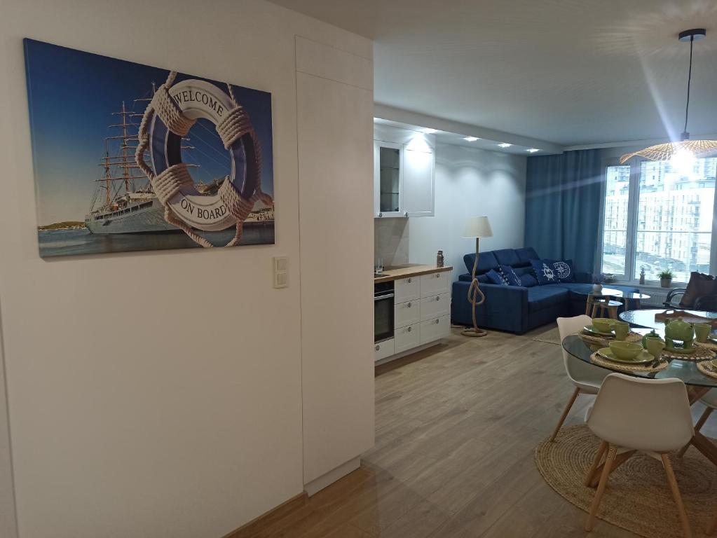 a living room with a table and a dining room at Apartament Baltic Sea -Przystań Letnica in Gdańsk