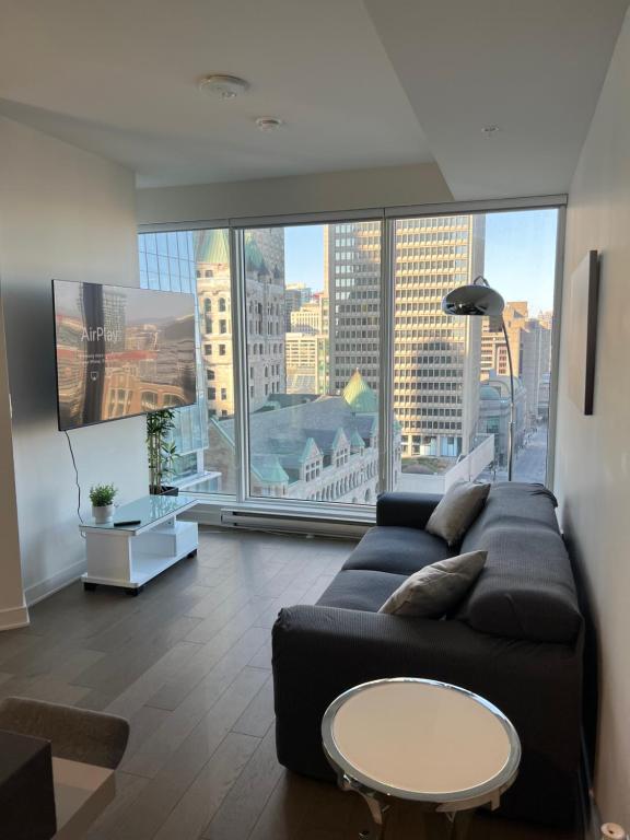 a living room with a couch and a large window at Beautiful one bedroom downtown Condo with pool and free parking in Montreal