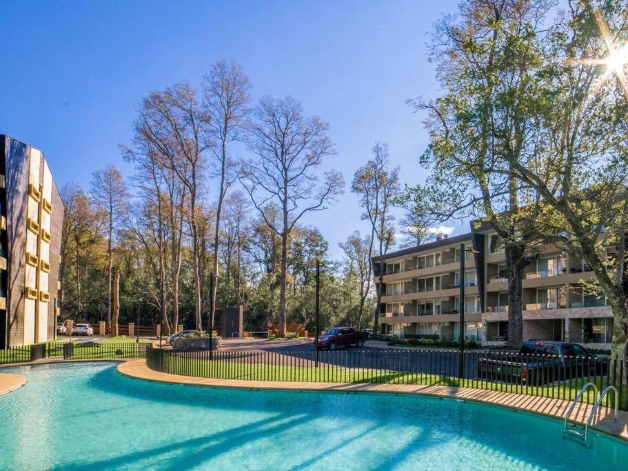 una piscina frente a un edificio en Departamento ALTA Vista Pucon, en Pucón