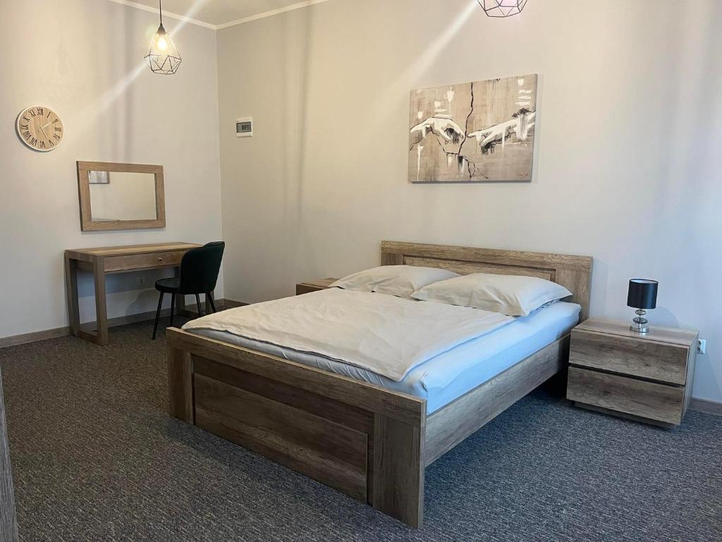 a bedroom with a bed and a desk with a chair at Noclegi Zator Energylandia in Spytkowice