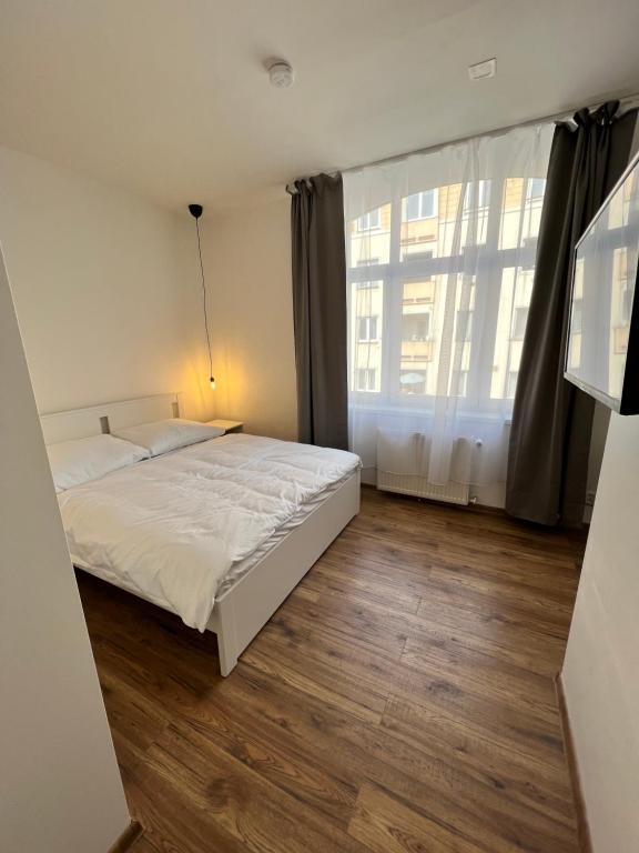a bedroom with a bed and a large window at Hotel & Cafe SokoLOVE in Sokolov
