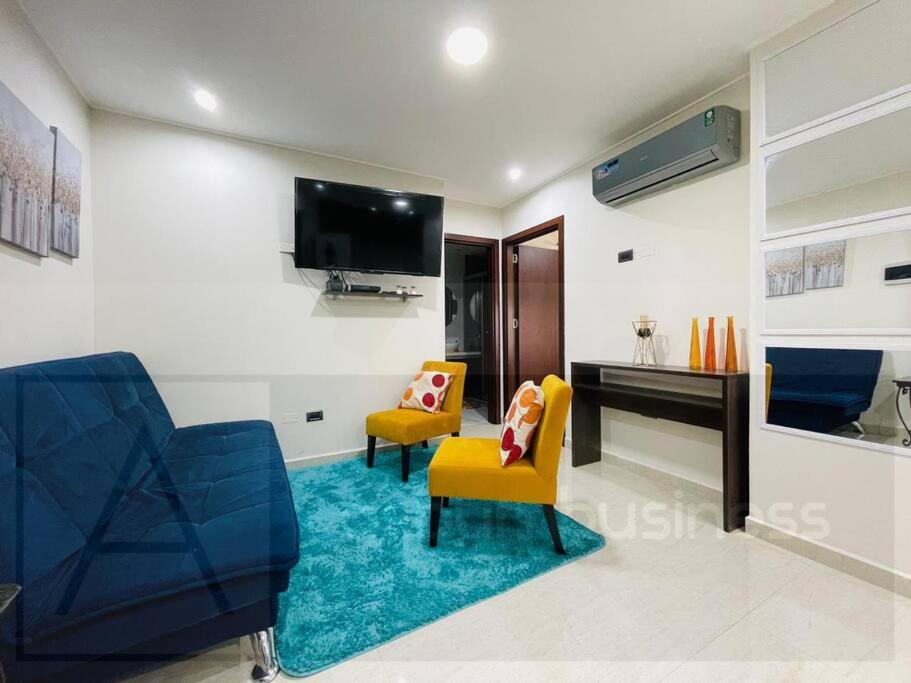 - un salon avec deux chaises et une télévision dans l'établissement Yovanna Elegante Apartamento 1 dormitorio, à Santa Cruz de la Sierra