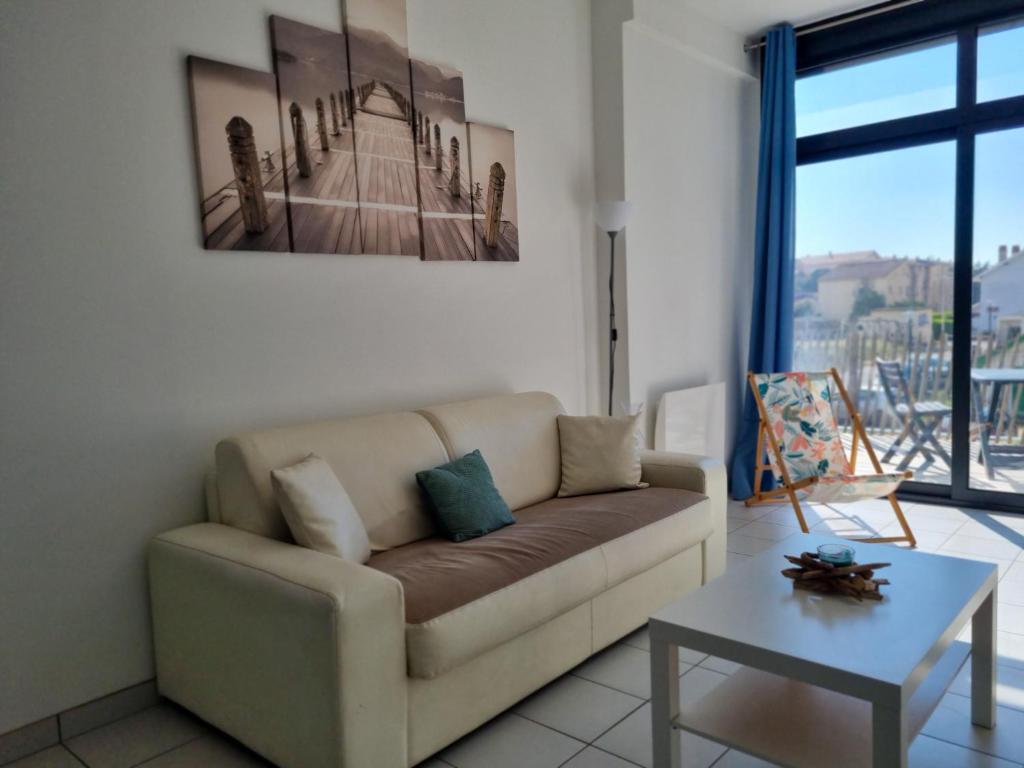 a living room with a couch and a table at A 200m de la plage - L'Océan - in Mimizan-Plage