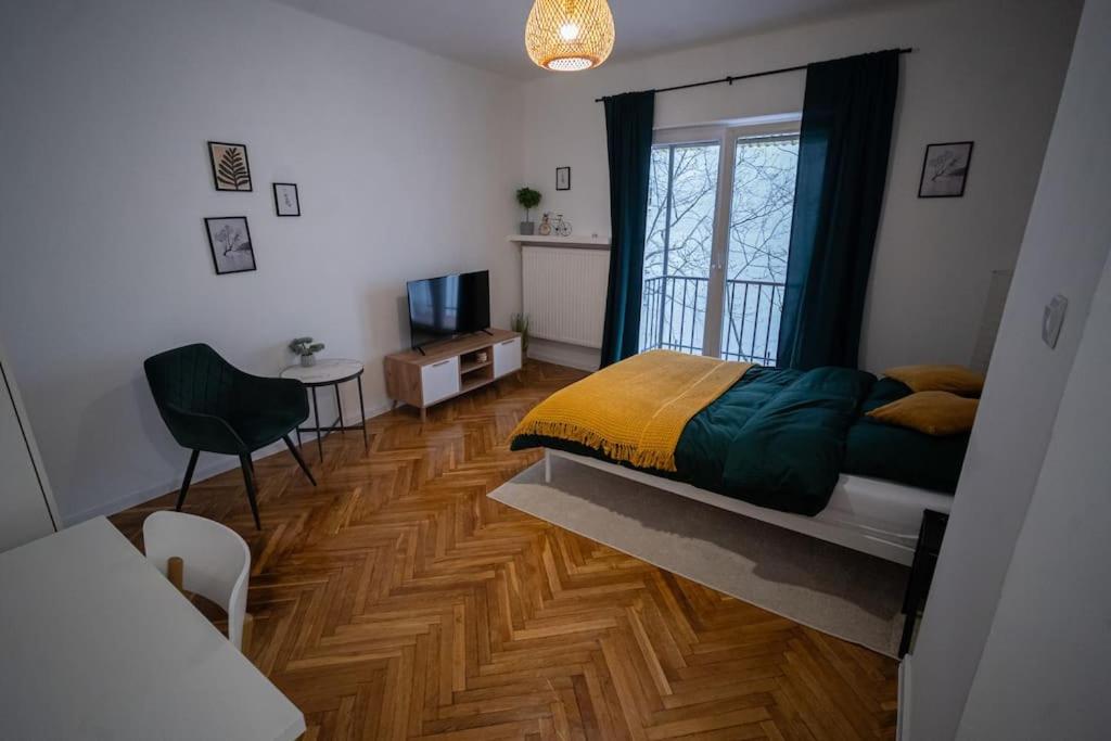 1 dormitorio con 1 cama y suelo de madera en Smulikowskiego Apartment en Varsovia