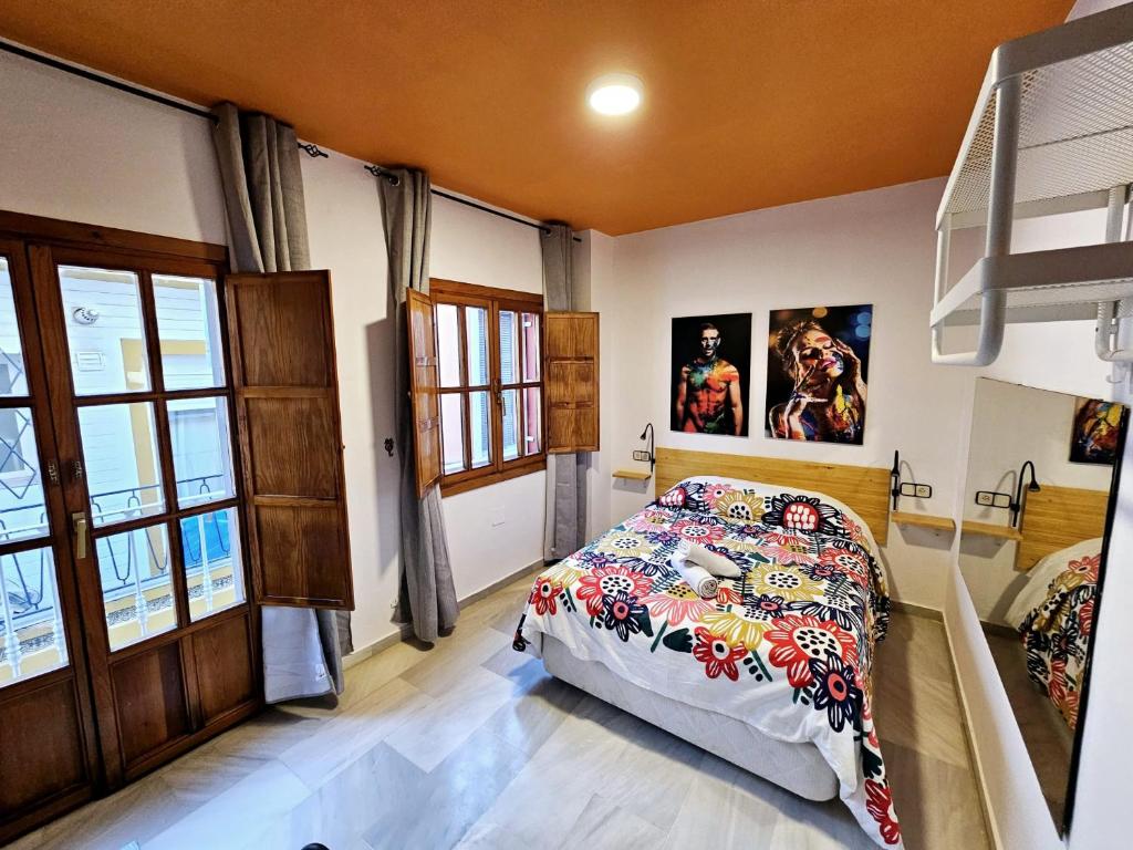 1 dormitorio con 1 cama y algunas fotos en la pared en Arc House Plaza en Sevilla