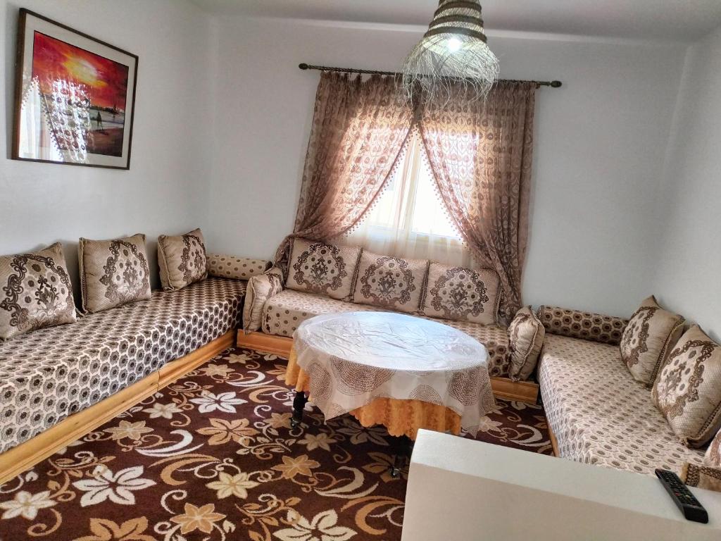 sala de estar con sofá y mesa en Appartement calme et confortable, en Al Ghar