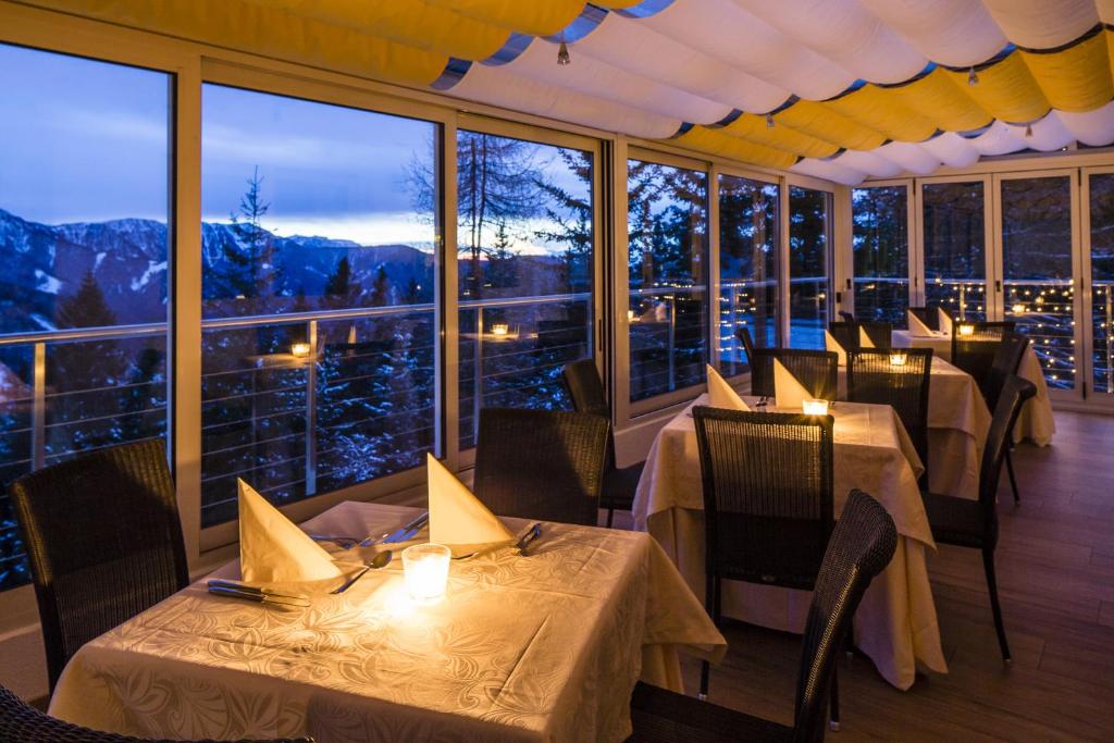 a restaurant with tables and chairs with a view of the mountains at Aurora in Plancios
