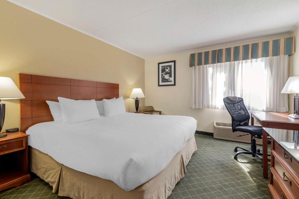 a hotel room with a large bed and a desk at Best Western Plus Augusta Civic Center Inn in Augusta