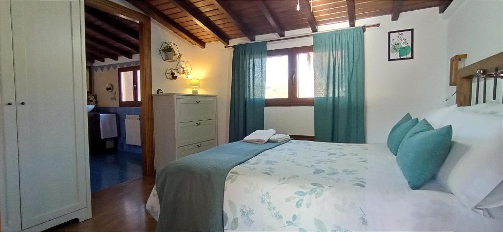 Un dormitorio con una cama grande y una ventana en Buhardilla Ca'tio Celso en San Esteban de la Sierra