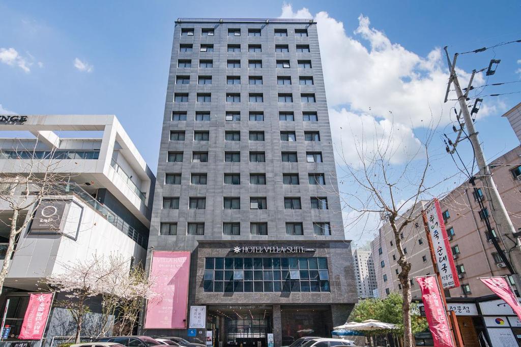 un edificio alto en medio de una ciudad en Vella Suite Hotel, en Suwon