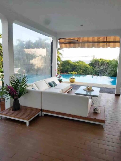 a living room with a white couch and a large window at YOU WELCOME VILLA in Case-Pilote