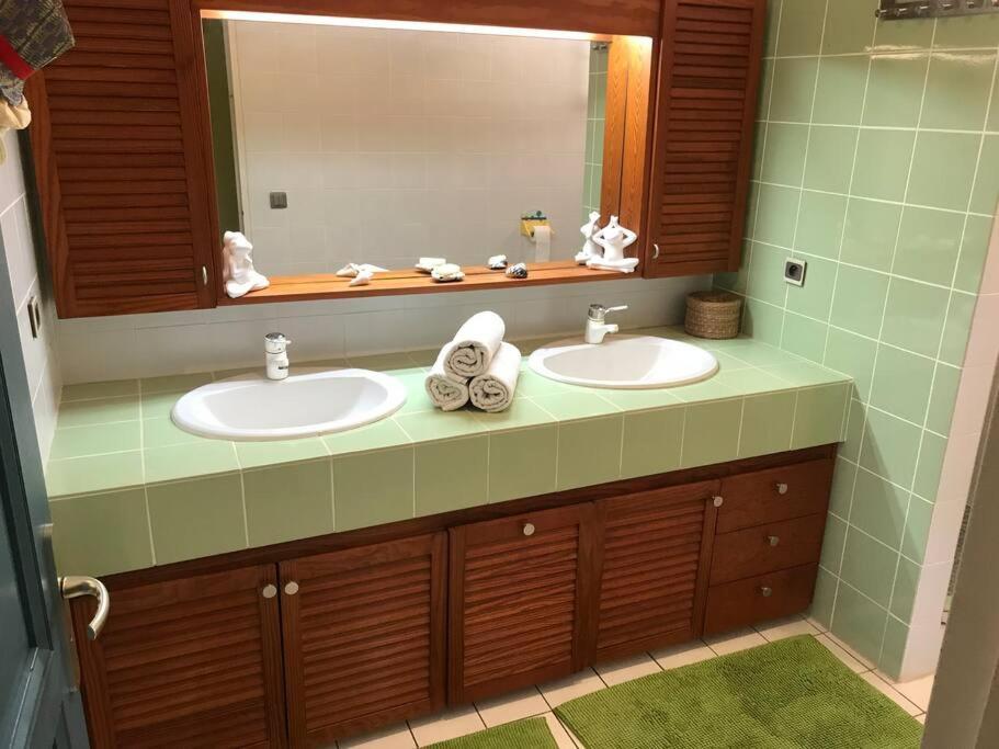 a bathroom with two sinks and a large mirror at YOU WELCOME VILLA in Case-Pilote