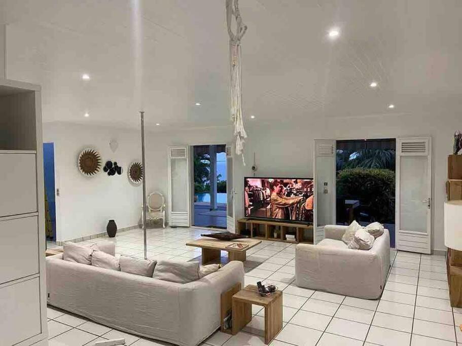 a living room with two couches and a flat screen tv at YOU WELCOME VILLA in Case-Pilote