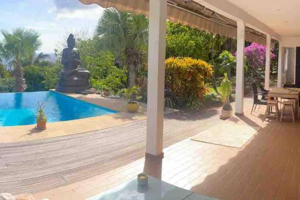 a patio with a statue in the back of a house at YOU WELCOME VILLA in Case-Pilote