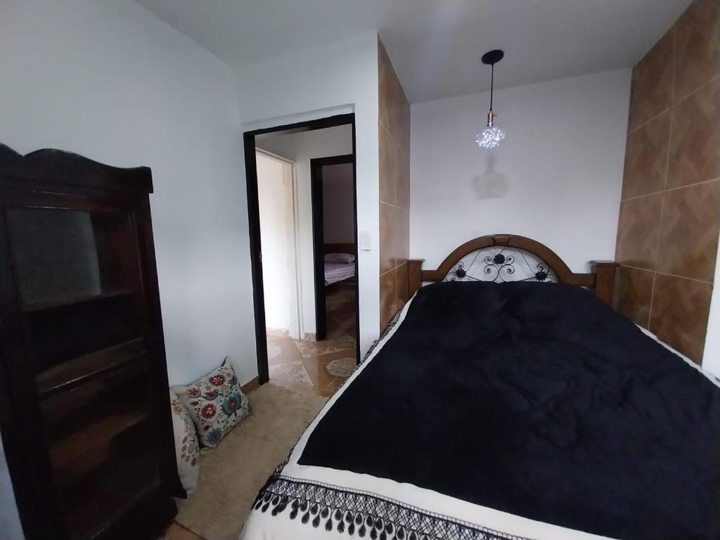 a bedroom with a bed with a black comforter at Los balcones ll in Medellín