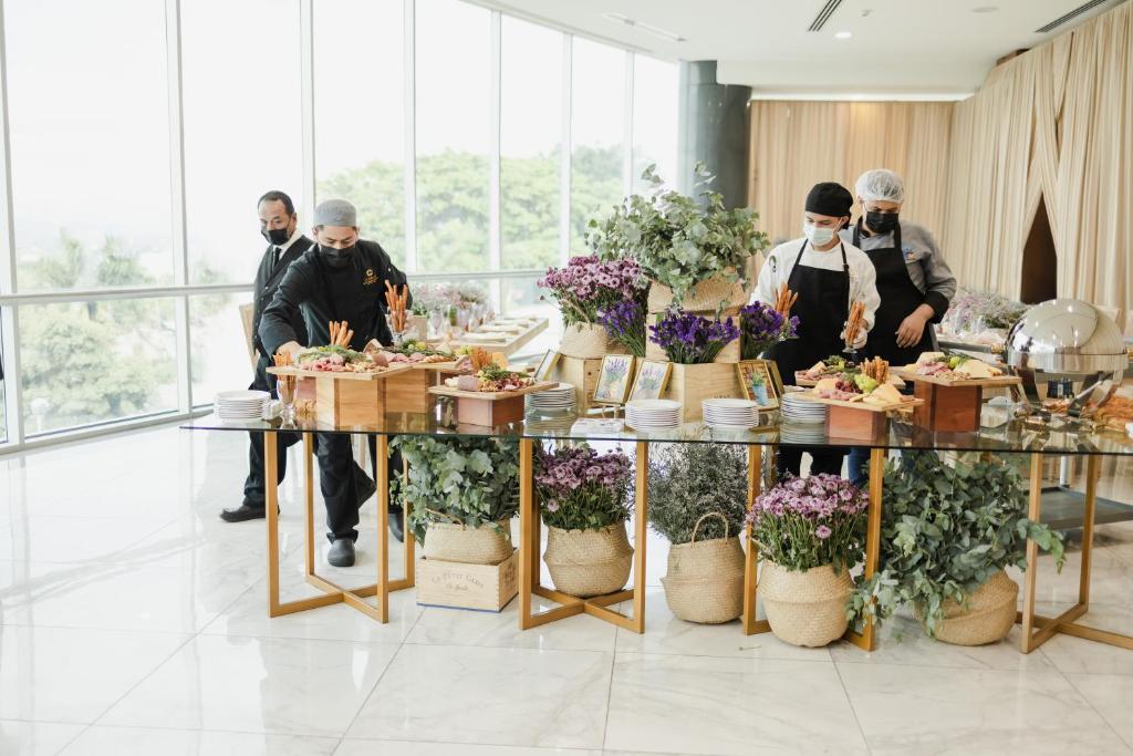 a group of people standing around a table with flowers at Copantl Hotel & Convention Center in San Pedro Sula