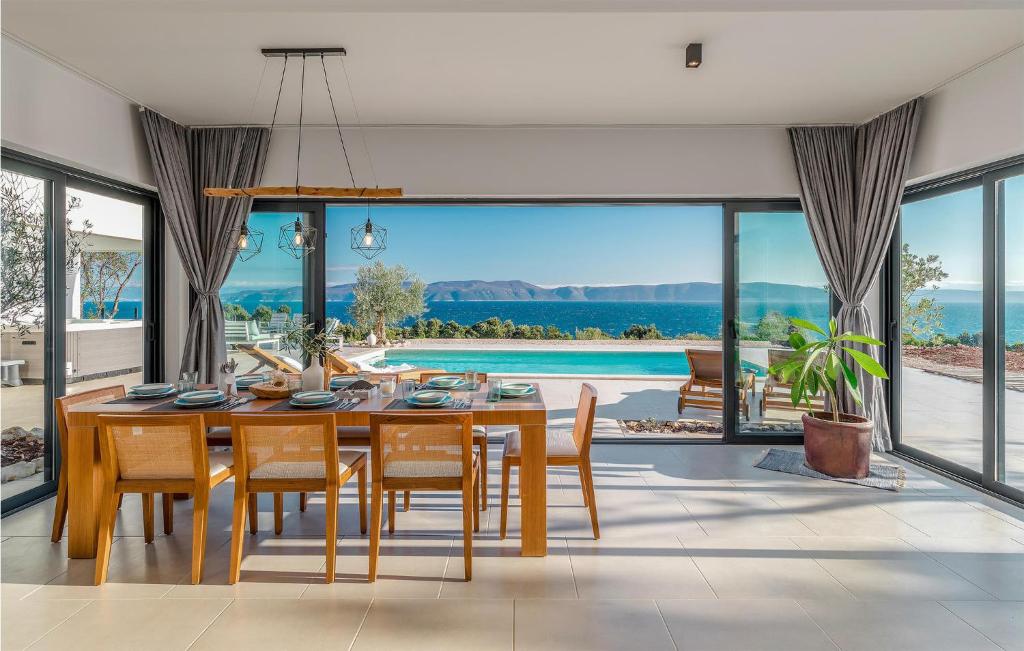 a dining room with a table and chairs and a pool at Nice Home In Ravni With Sauna in Ravni