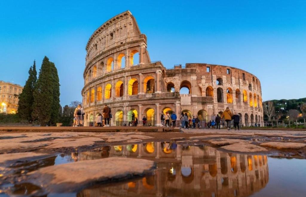 a view of the colosseum at night at Termini Palace Guesthouse in Rome