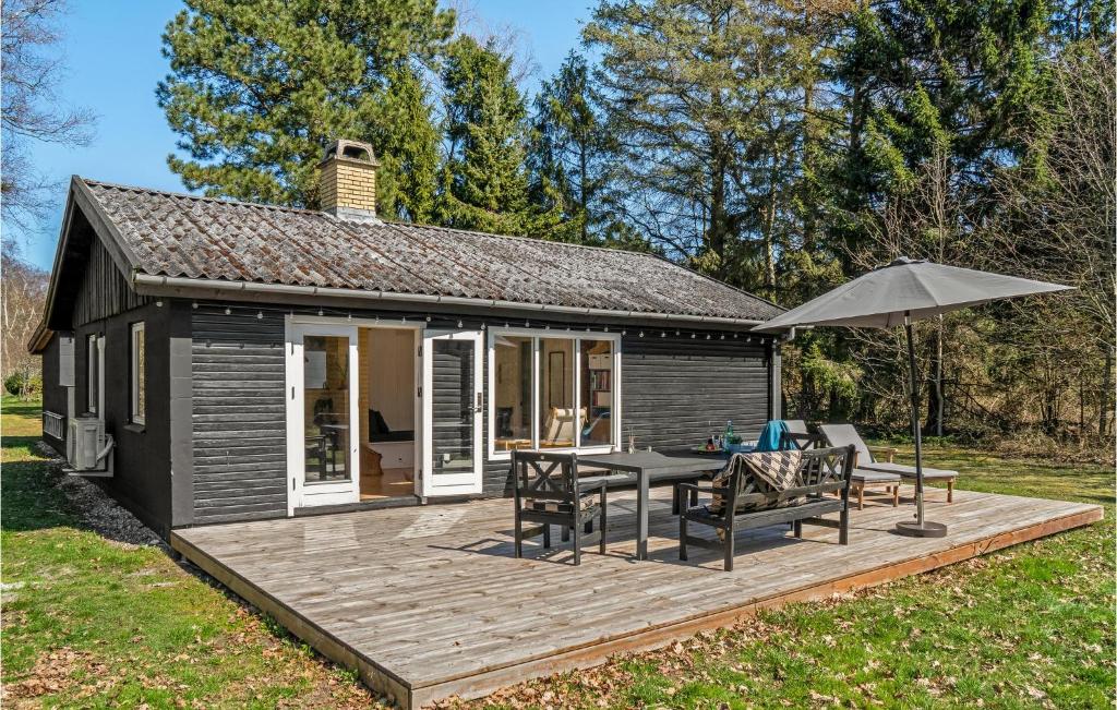 une petite cabine avec une terrasse et un parasol dans l'établissement Beautiful Home In Rrvig With Wifi, à Rørvig