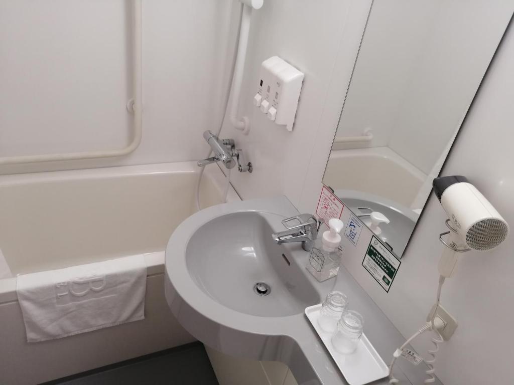 a bathroom with a sink and a mirror at Washington R&B Hotel Hachioji in Hachioji