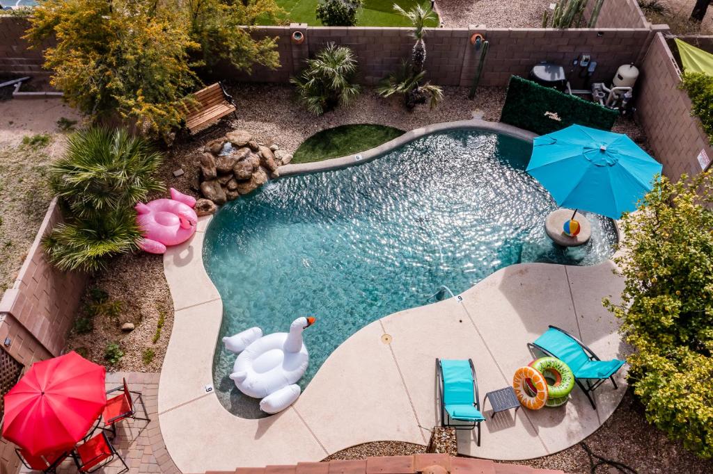 an overhead view of a swimming pool with umbrellas and chairs at Chic Poolside Oasis - Karaoke - BBQ - Games in Phoenix