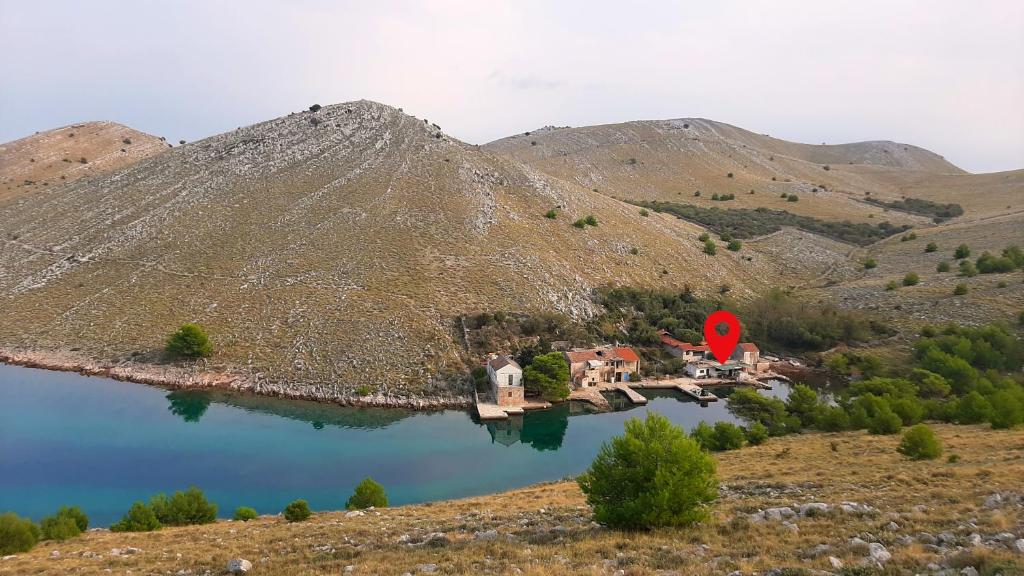 an island in the middle of a lake in a mountain at Secluded fisherman's cottage Cove Lupescina, Kornati - 18657 in Murter